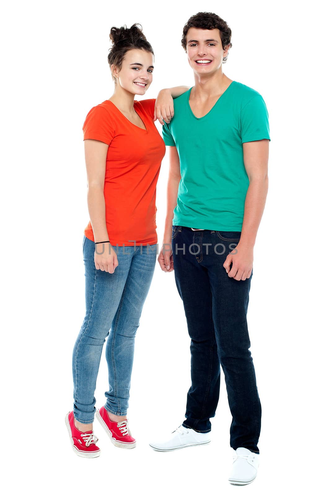 Full length portrait of fashionable young couple. Girl resting her hand on boy's shoulder
