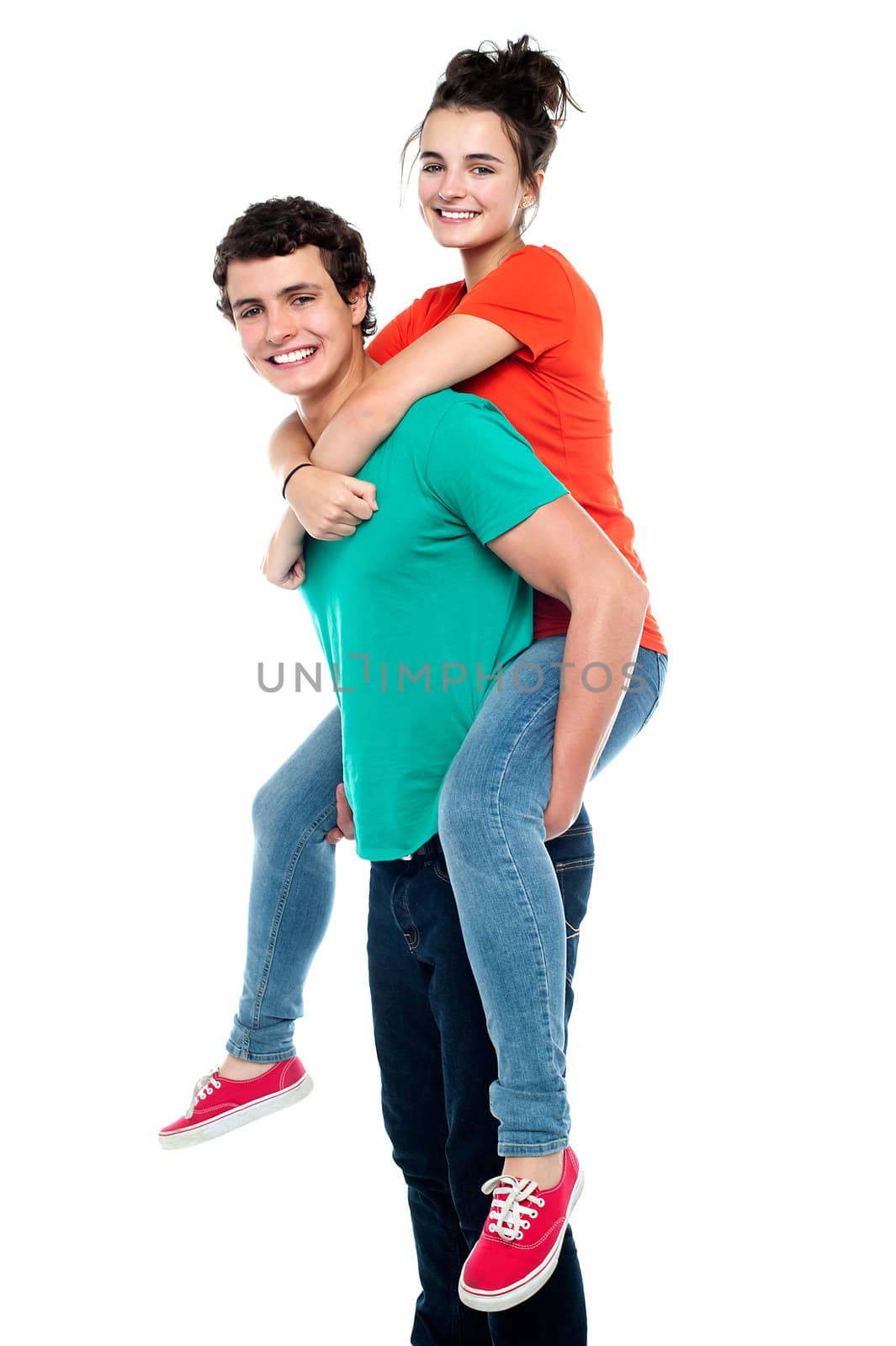 Portrait of a handsome young man giving a piggyback ride to his girlfriend - Indoor