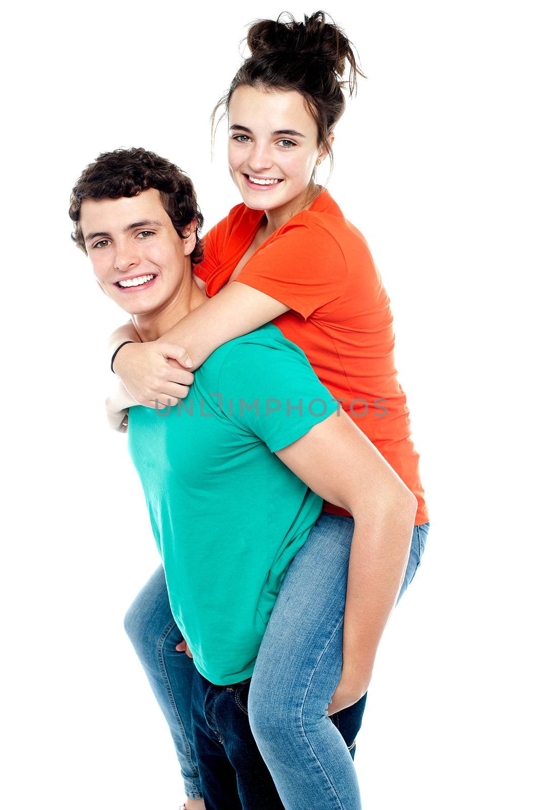 Happy young girl enjoying piggyback ride on her boyfriend back by stockyimages