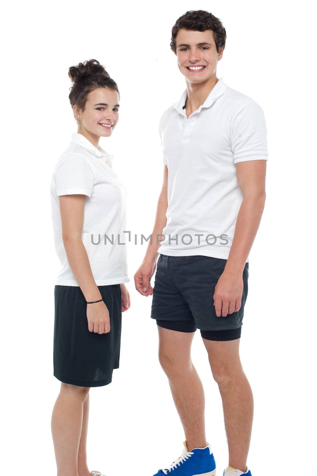 Teen couple in sportswear posing casually. Smiling in front of camera