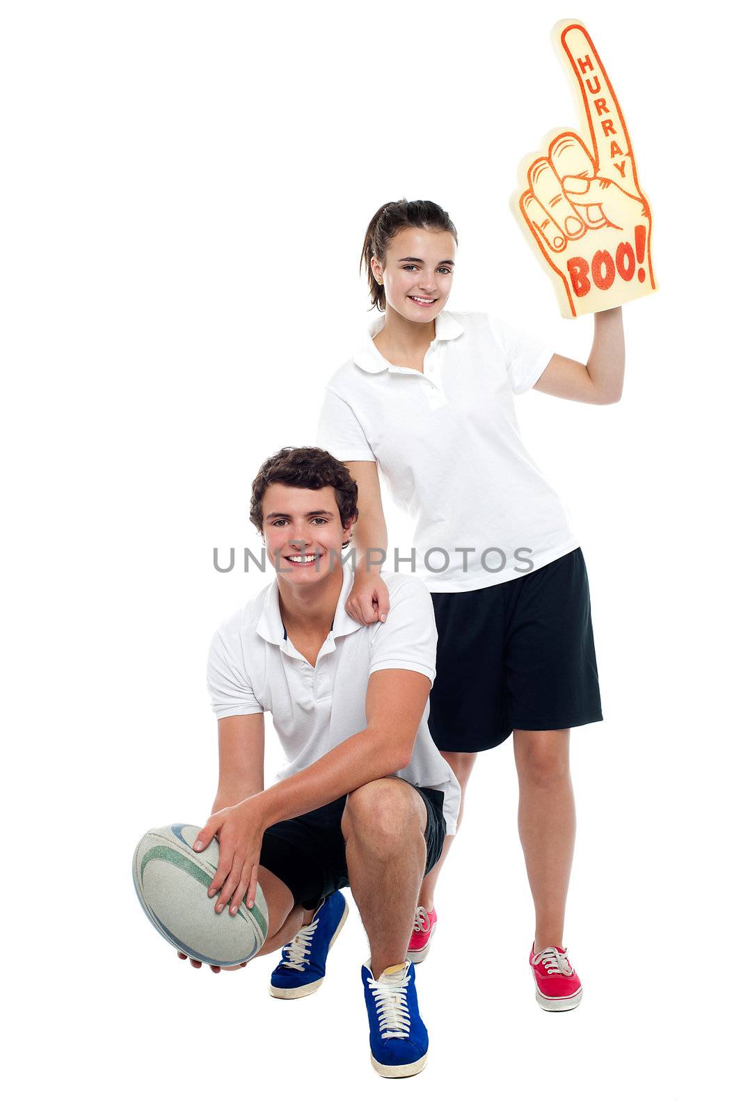 Cheerleader fan girl posing with football team player. Studio shot