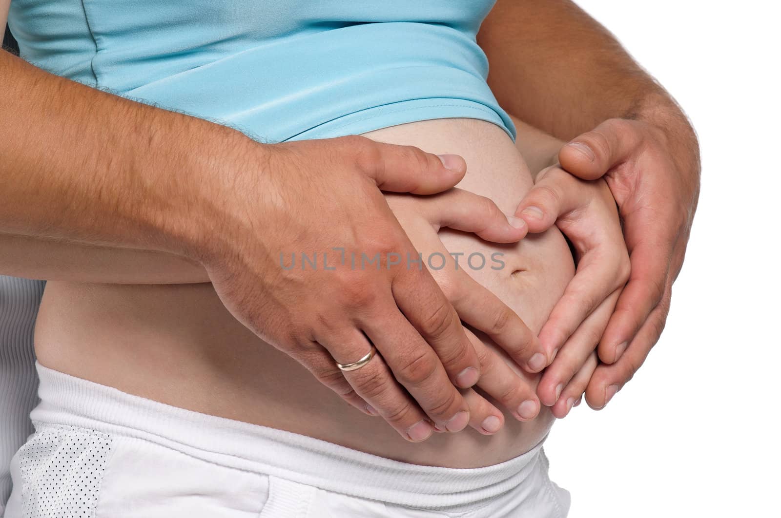 Hands of pregnant woman and her husband in heart shape on white background