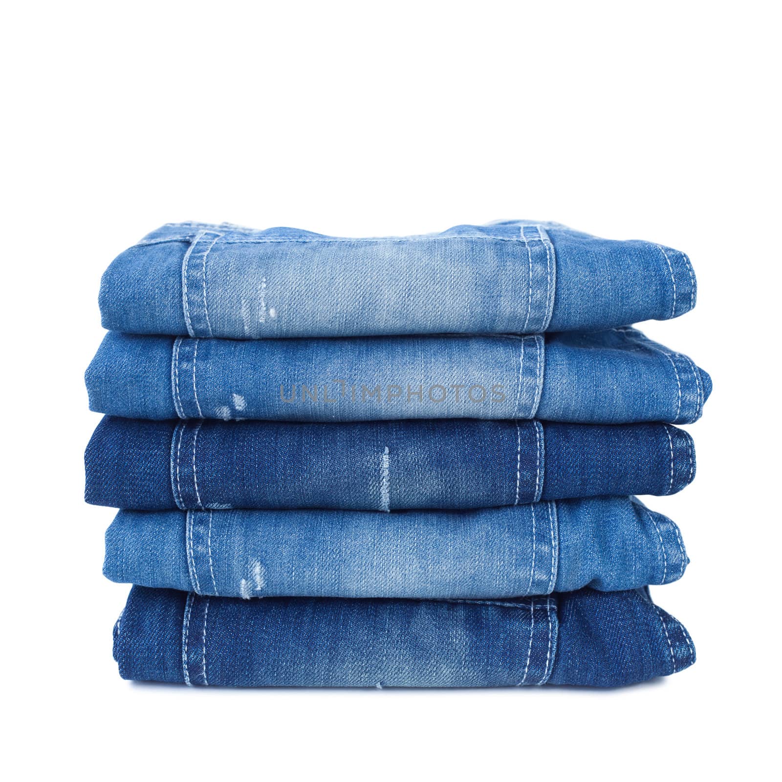 Stack of blue jeans isolated on white background