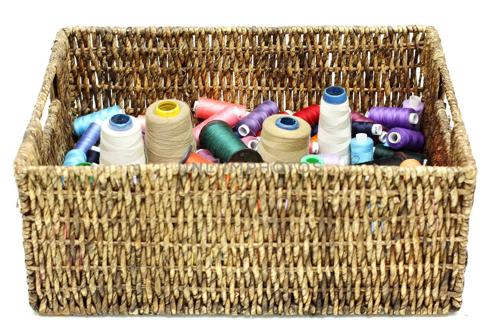 Many colorful spools of thread in the wicker baskets