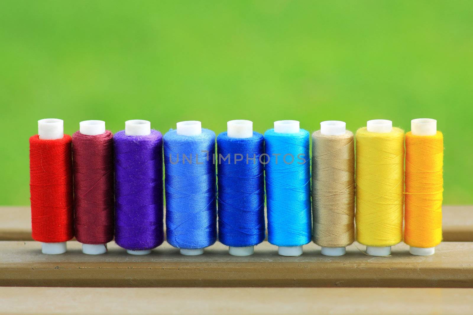 Many colorful spools of thread in a row