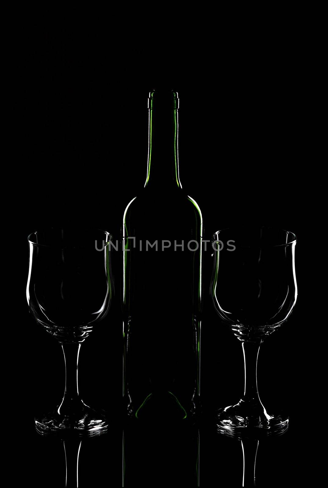 Wine bottle and wine glasses on a black background