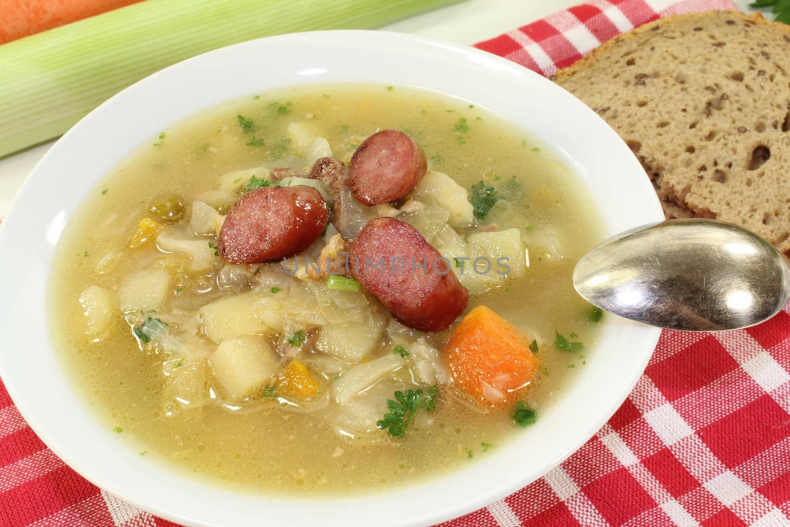 fresh white cabbage soup with vegetables, fried sausage and bread