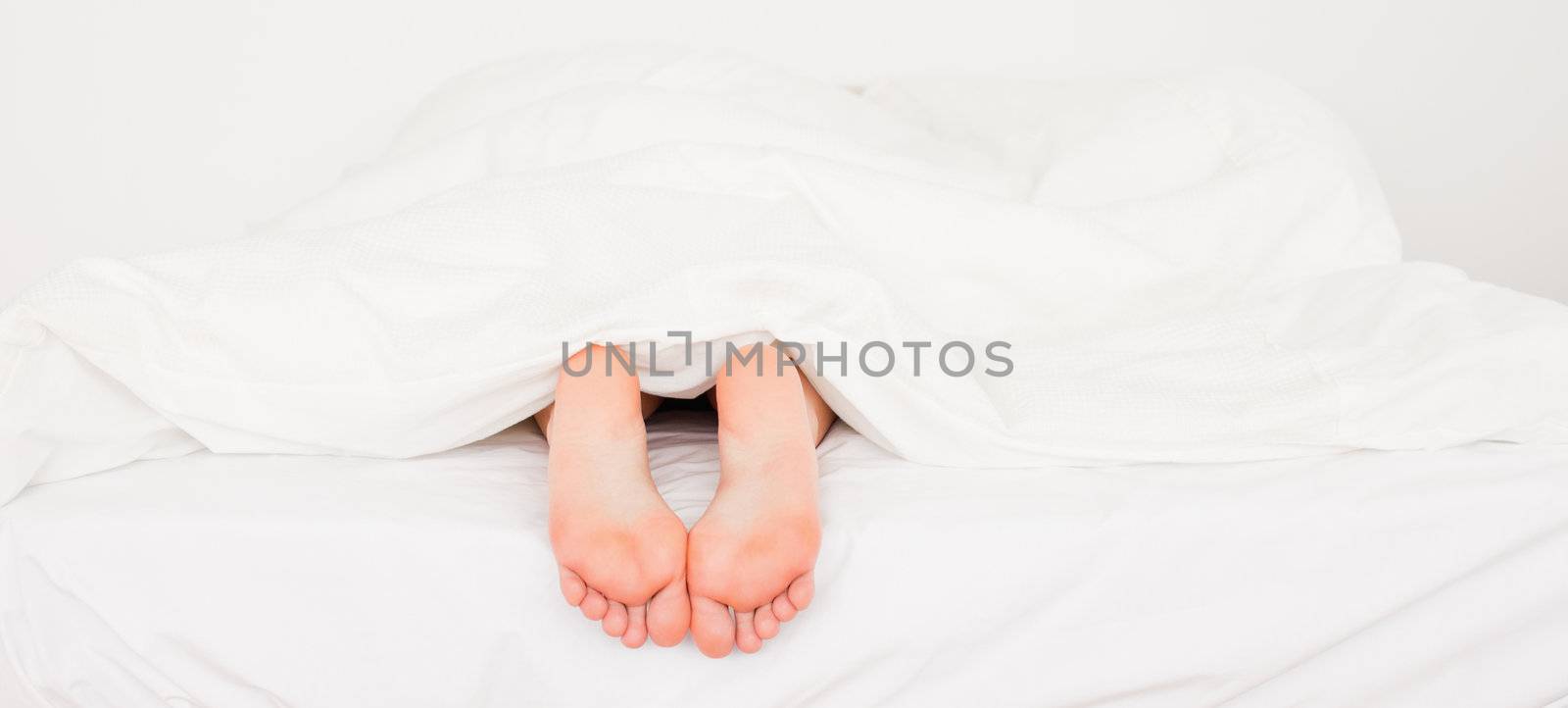 Two white feet in a bed