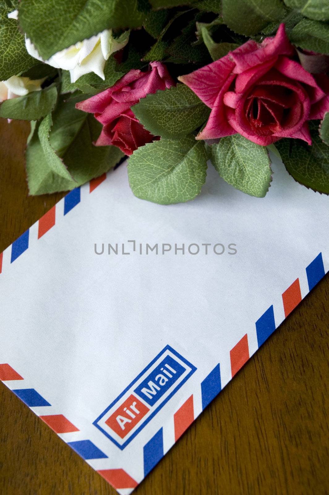Blank airmail envelope and bouquet of roses