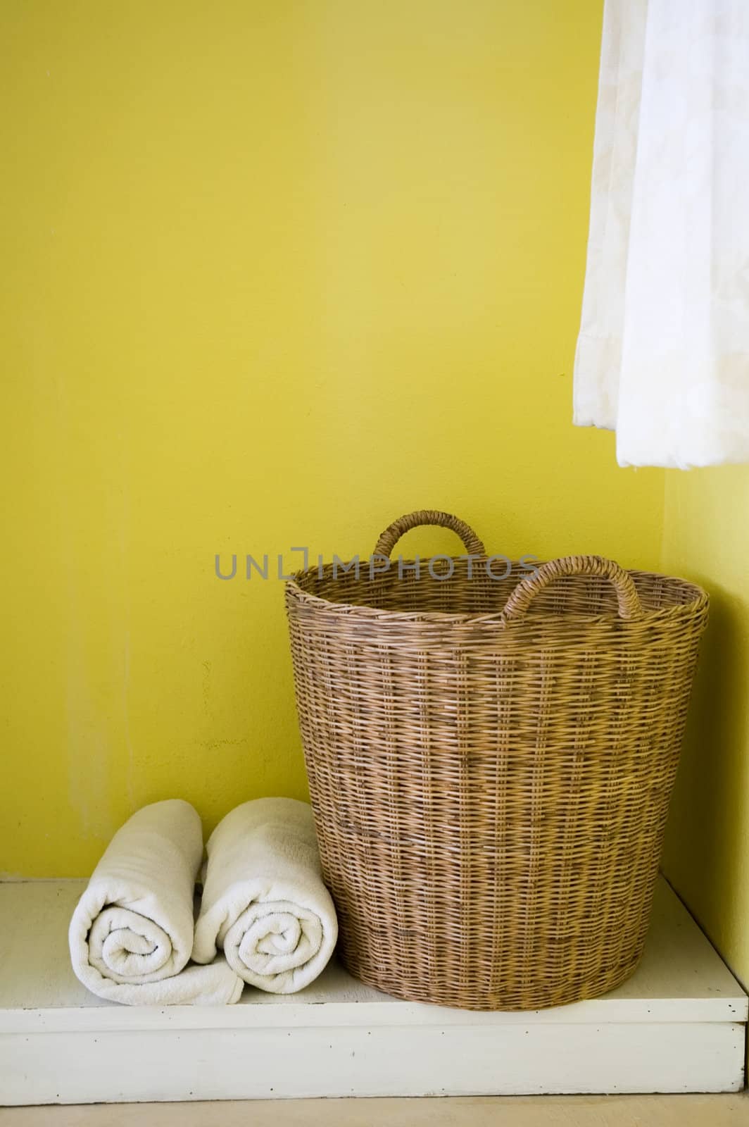 big basket and towels in yellow background.