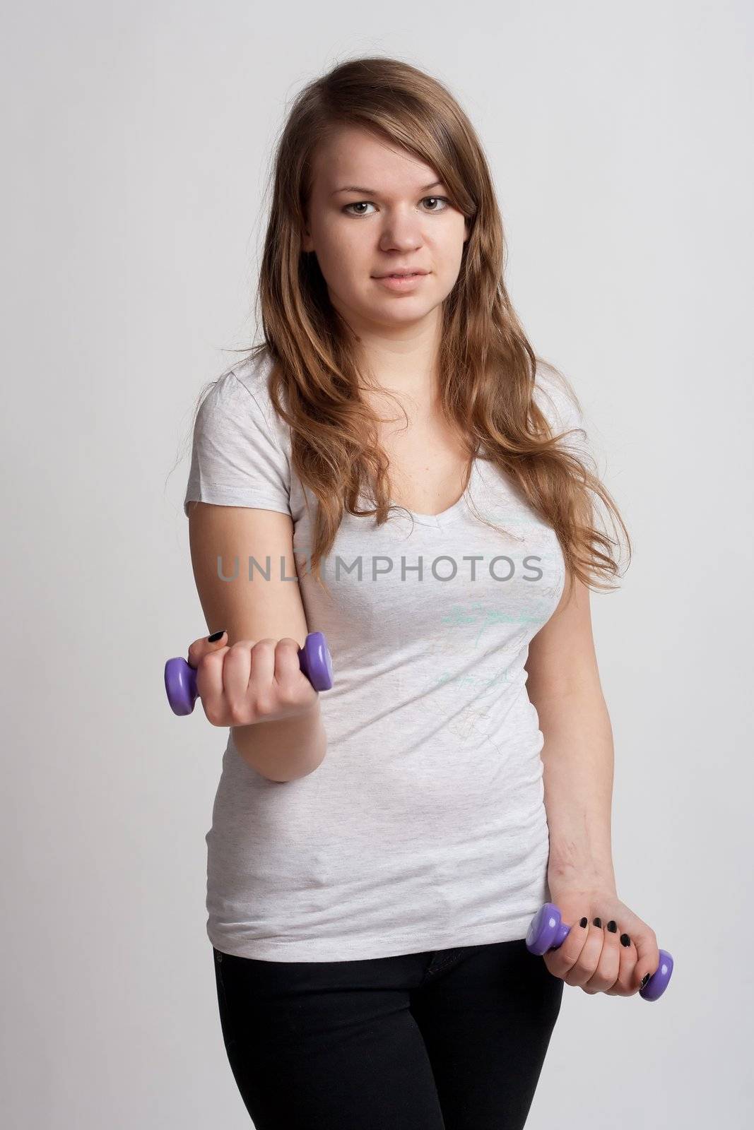 girl on a white background with dumbbells in hand