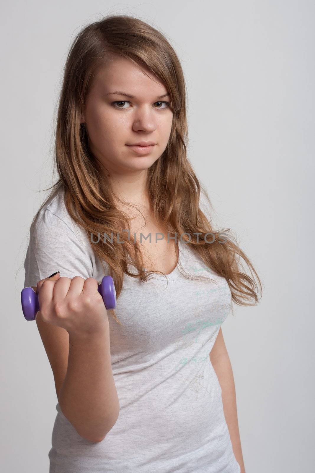 girl on a white background with dumbbells in hand