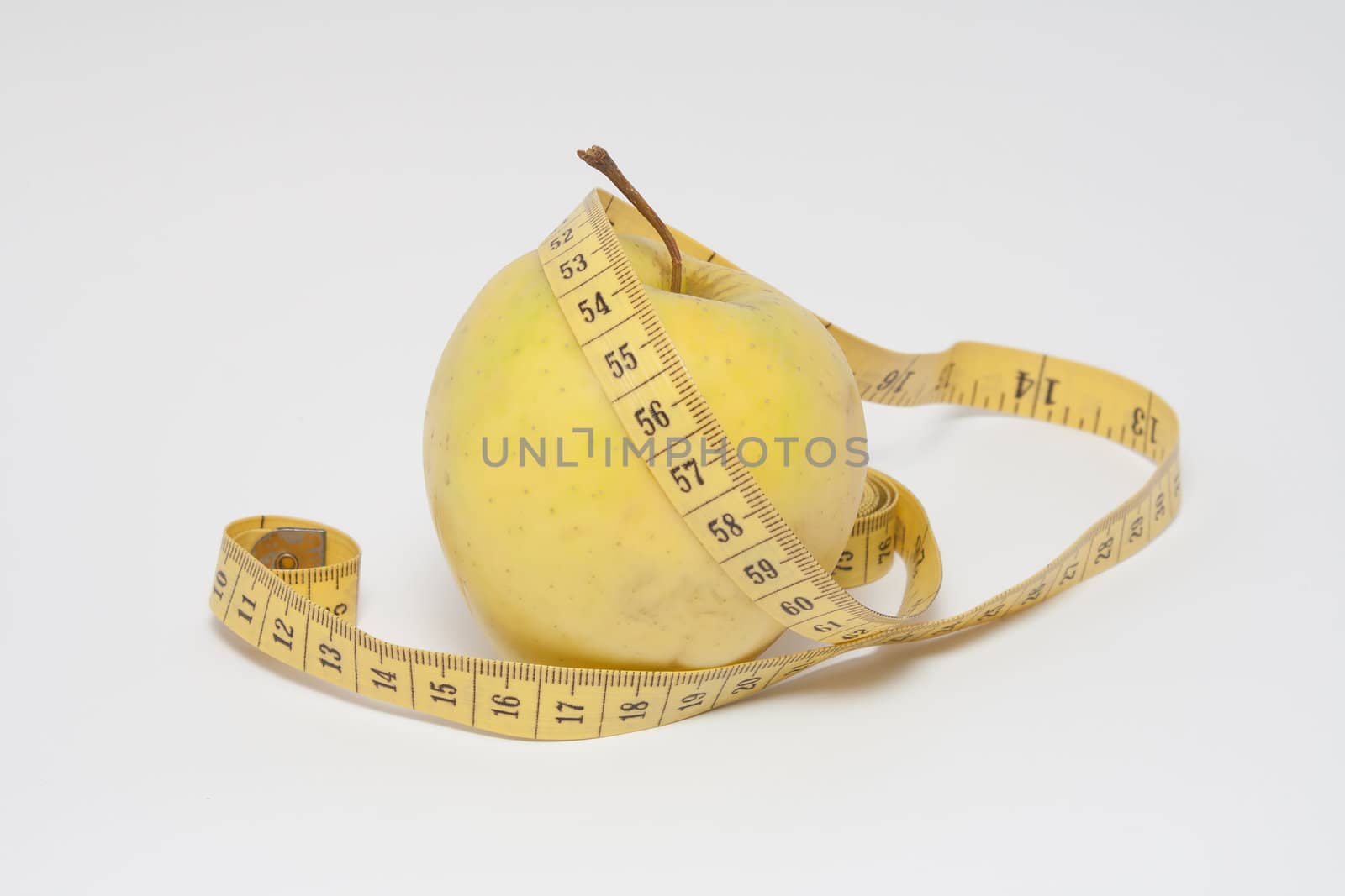 yellow apple and a yellow measuring tape on white background