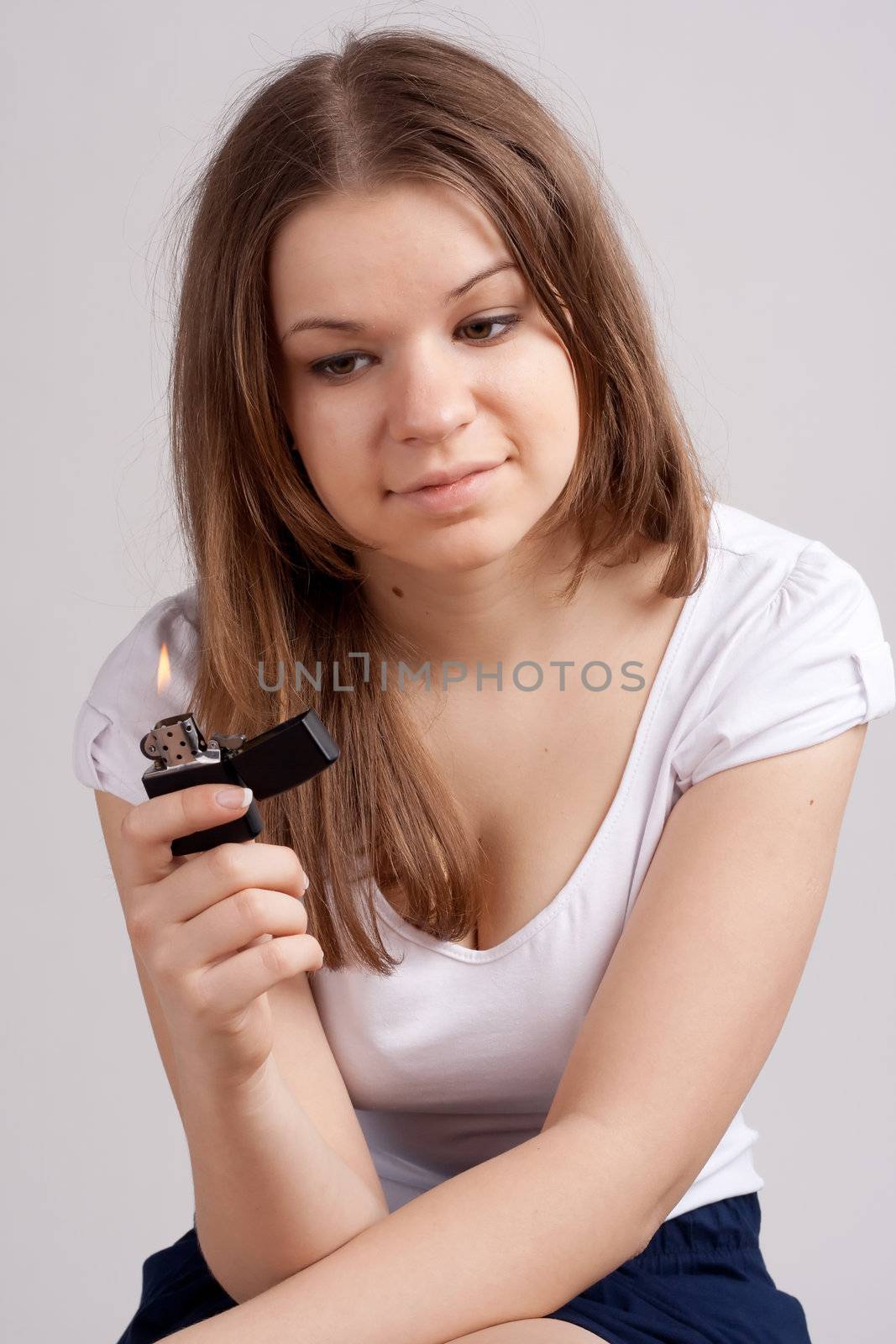 A girl holding a cigarette lighter and looks at her