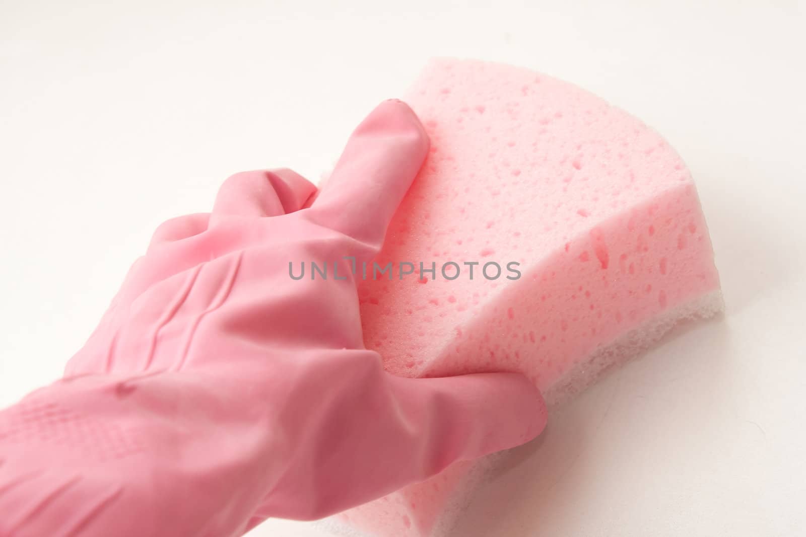 Hand in a pink rubber glove holding a pink sponge