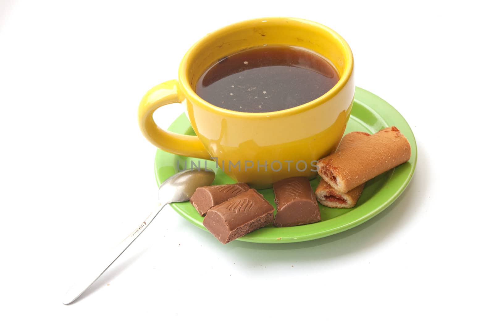 yellow cup of coffee with biscuits and chocolate on a white background