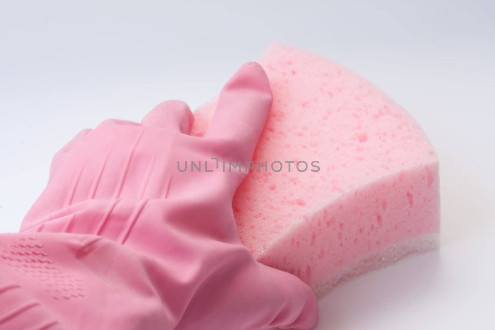 Hand in a pink rubber glove holding a pink sponge