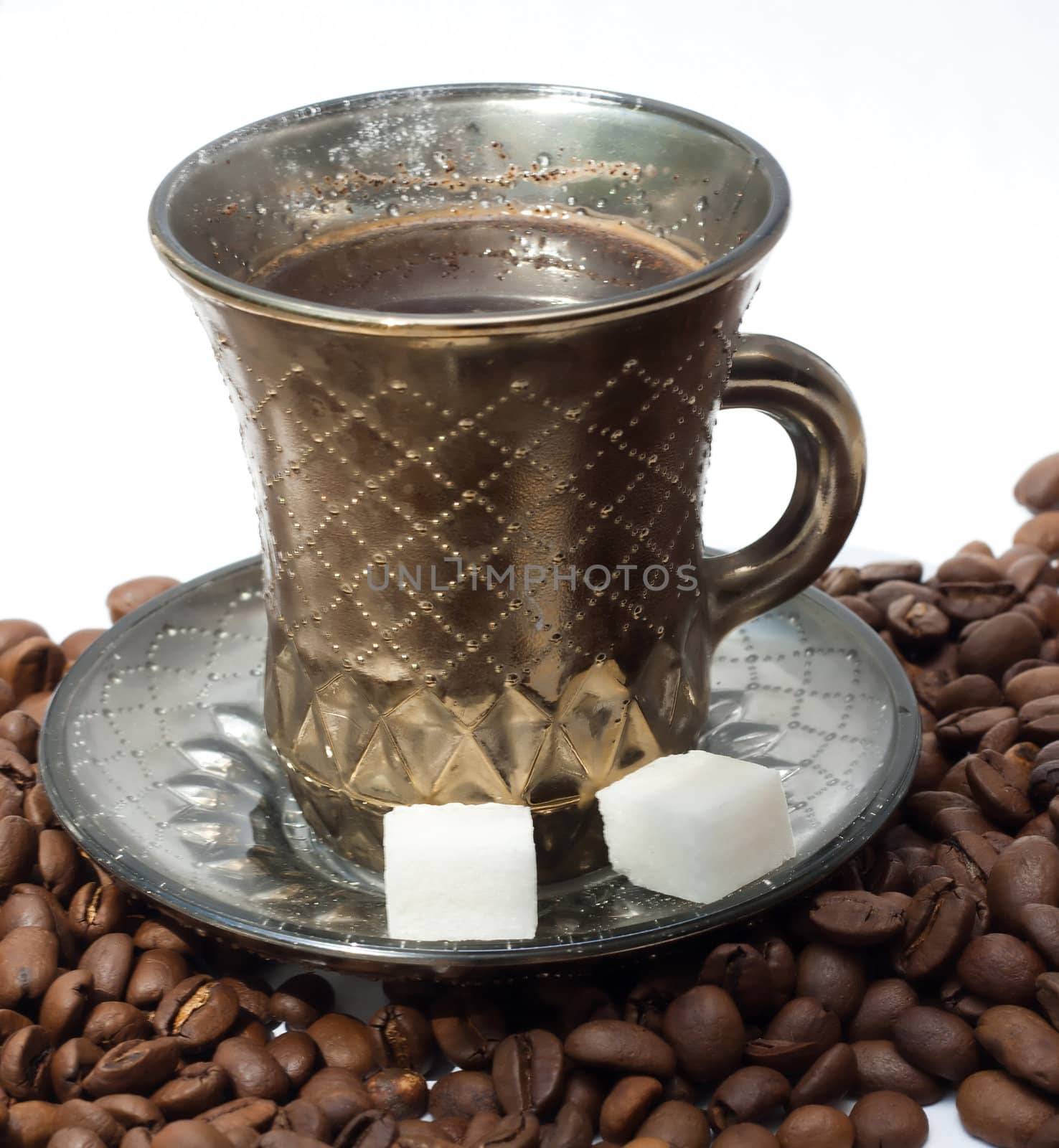 A cup of coffee is on the coffee beans on white background