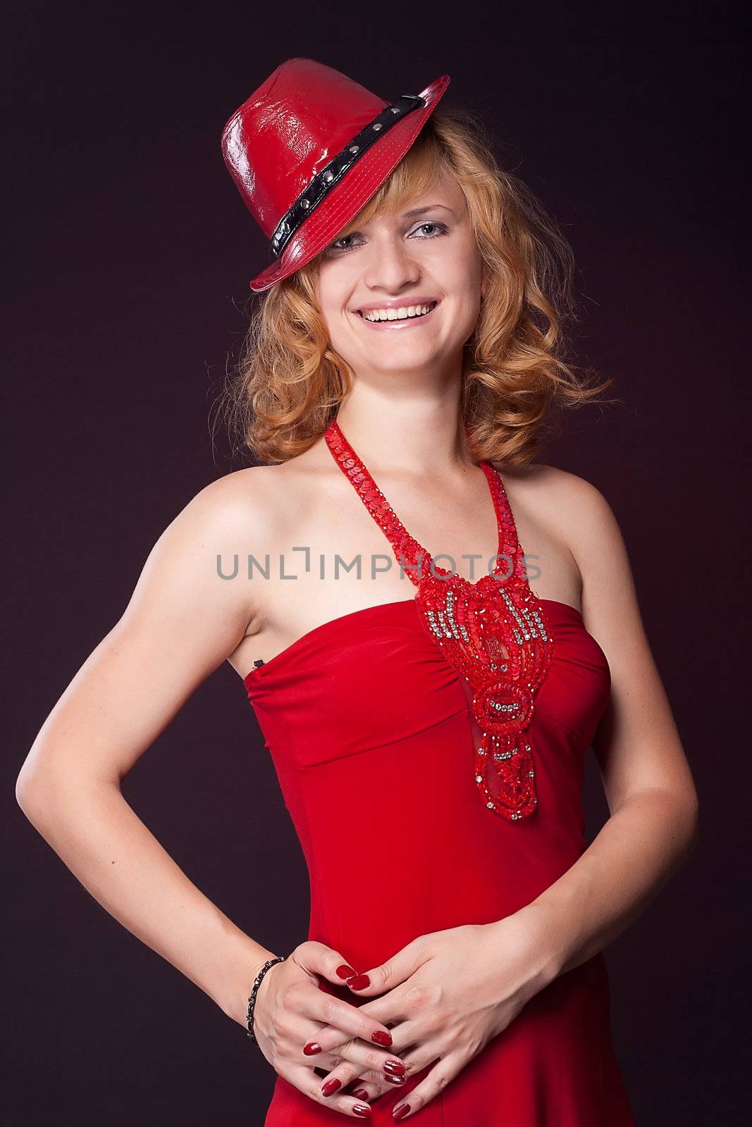 Beautiful girl in a red dress and red hat, studio photography