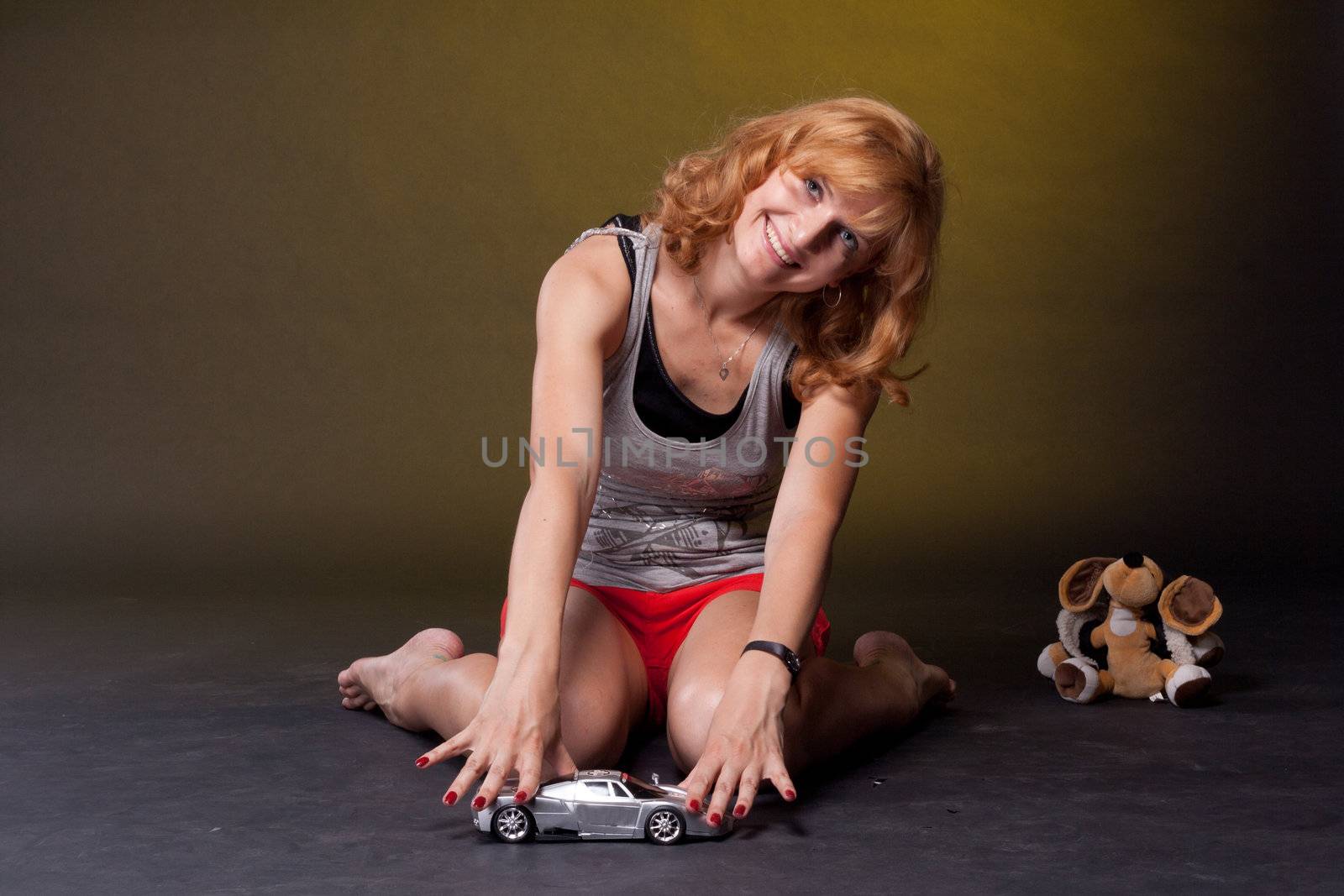 Red-haired girl with toys. Studio photography