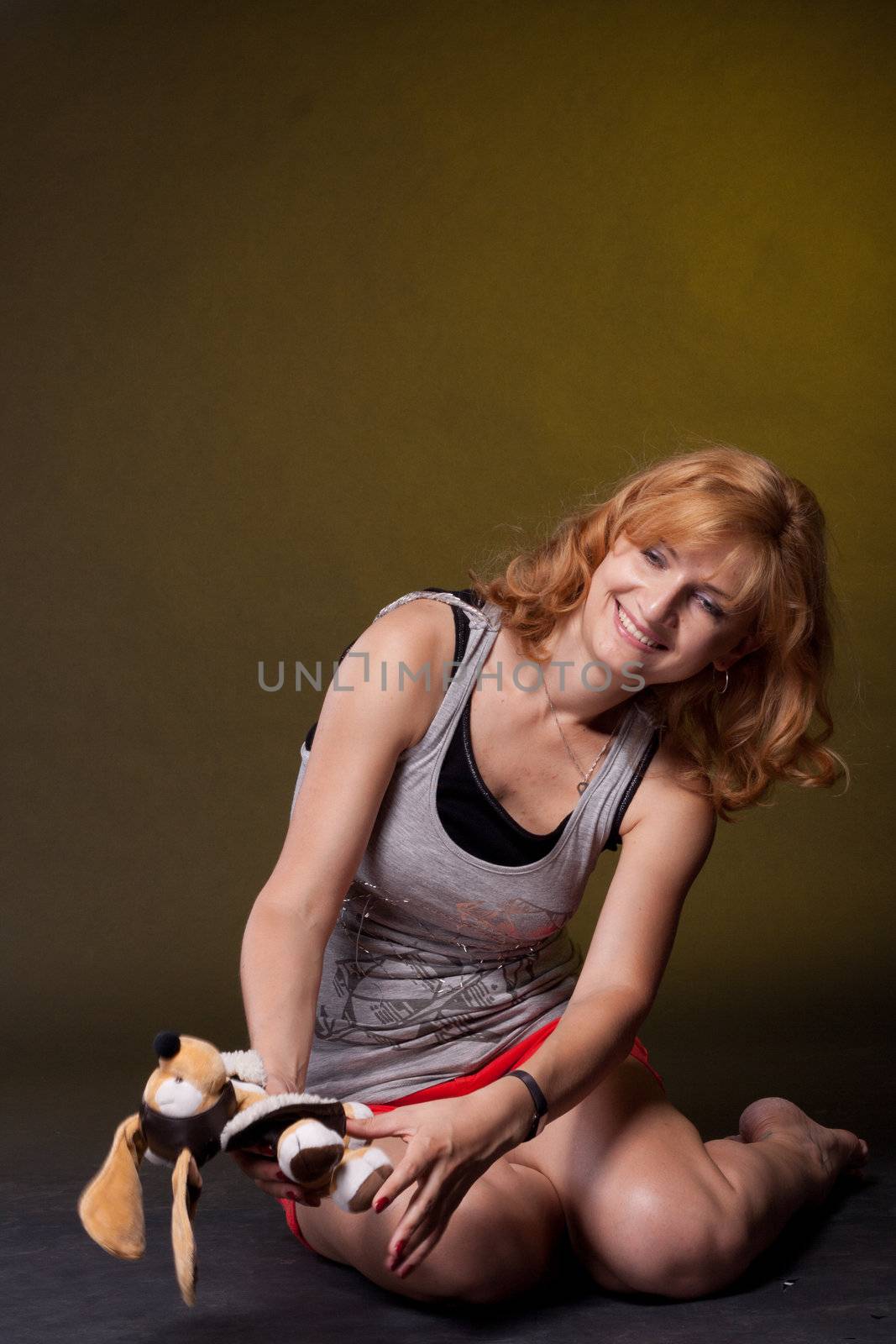 Red-haired girl with toys. Studio photography