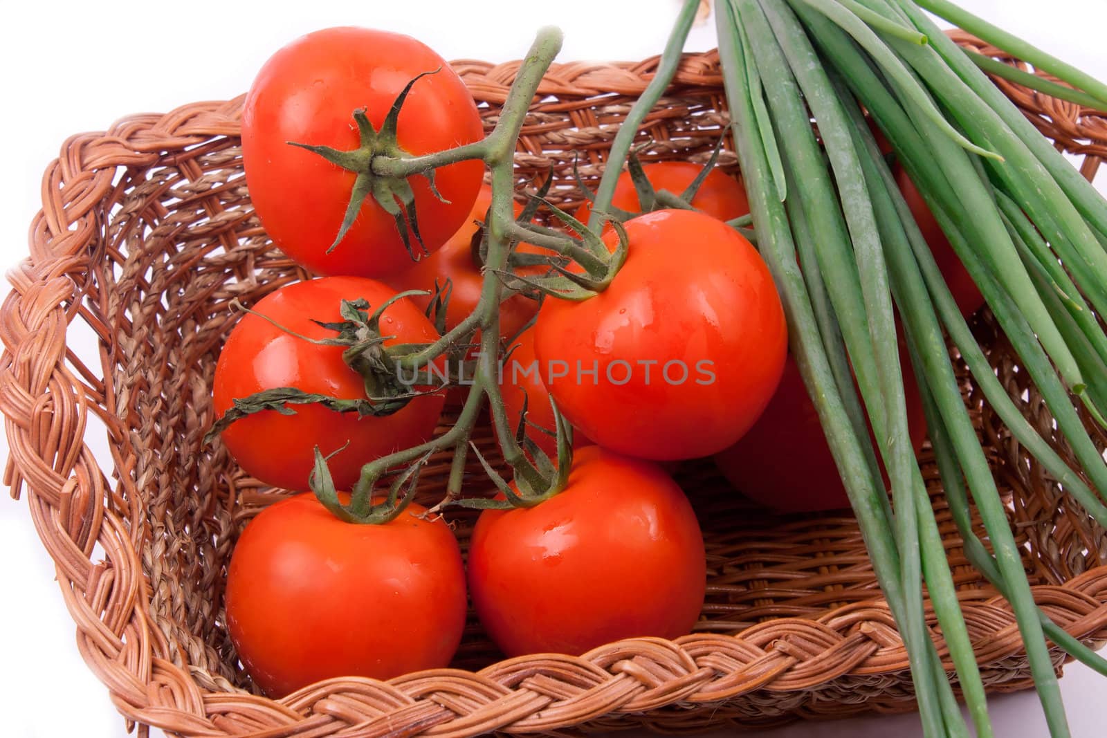 Red tomatoes in a basket on a white background