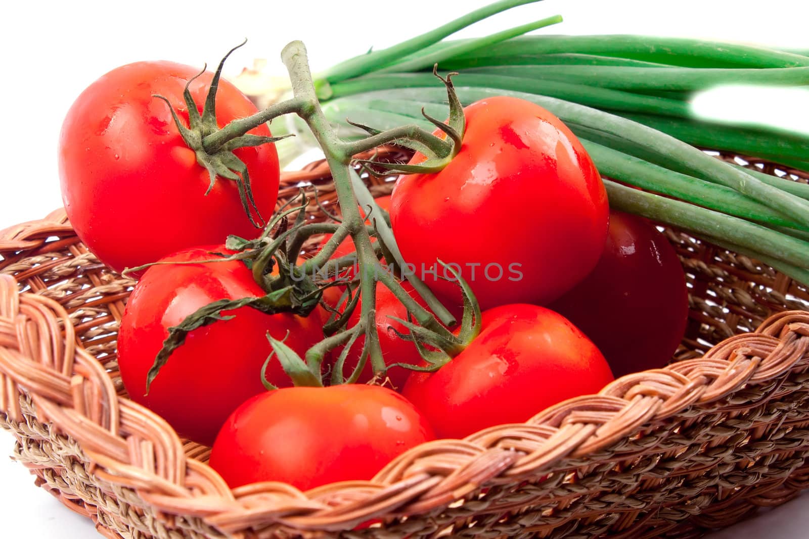 Red tomatoes in a basket on a white background