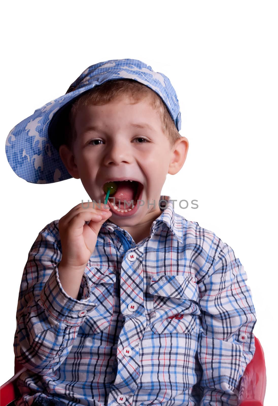 boy with an open mouth with a lollipop in his hand on a light background