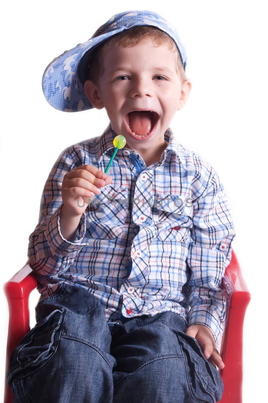 boy with an open mouth with a lollipop in his hand on a light background