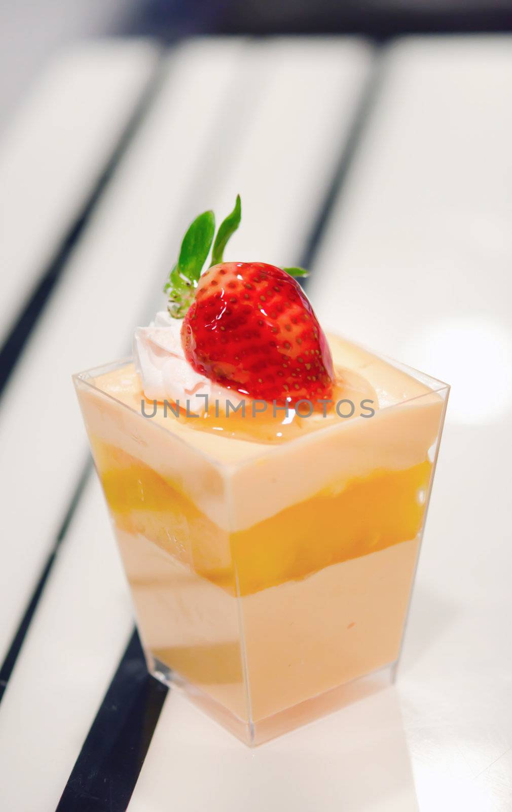 Orange cheese cake ,  decorated with fresh strawberries  , served in a bowl with a small 