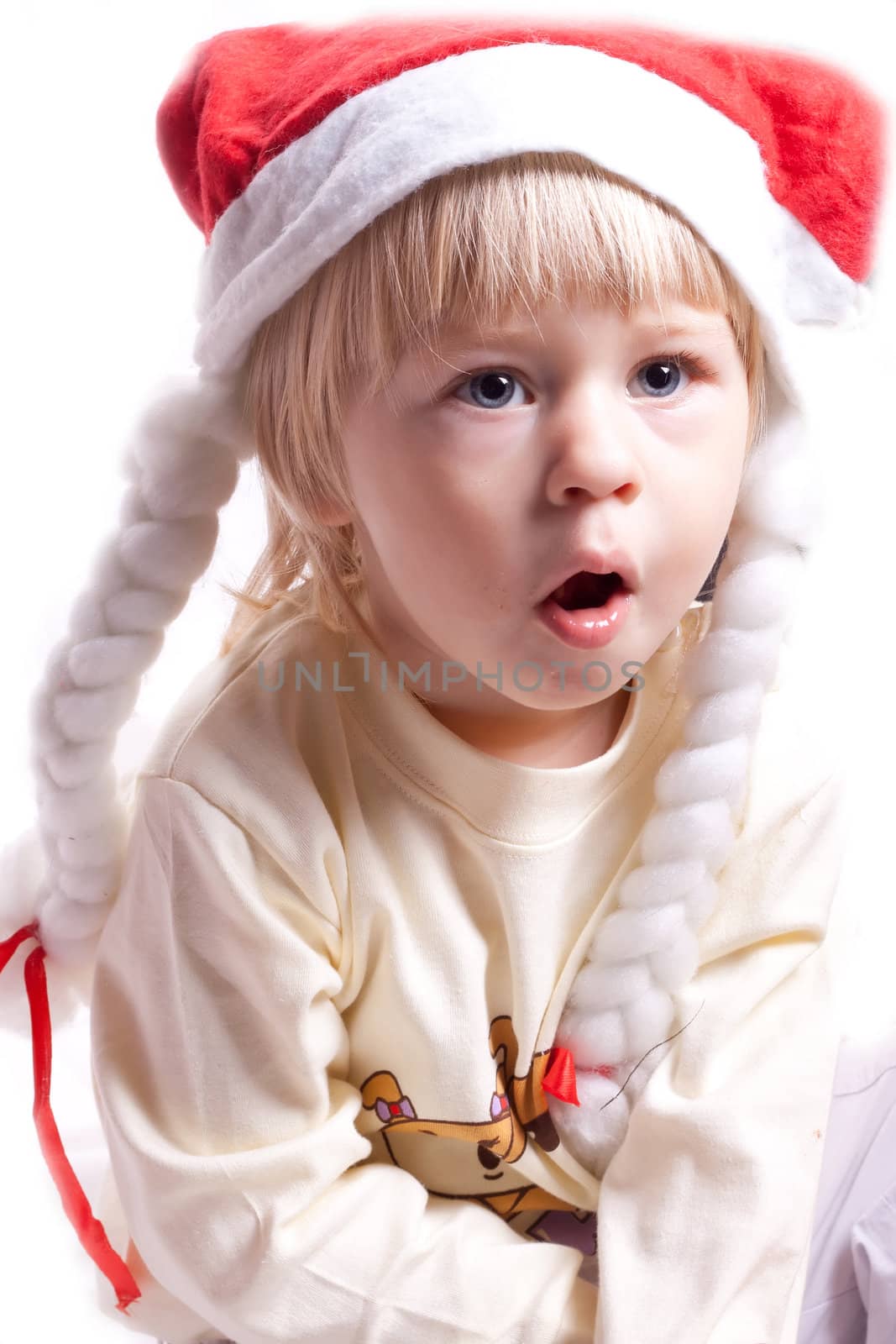 little girl in a Christmas hat with braids on a white background