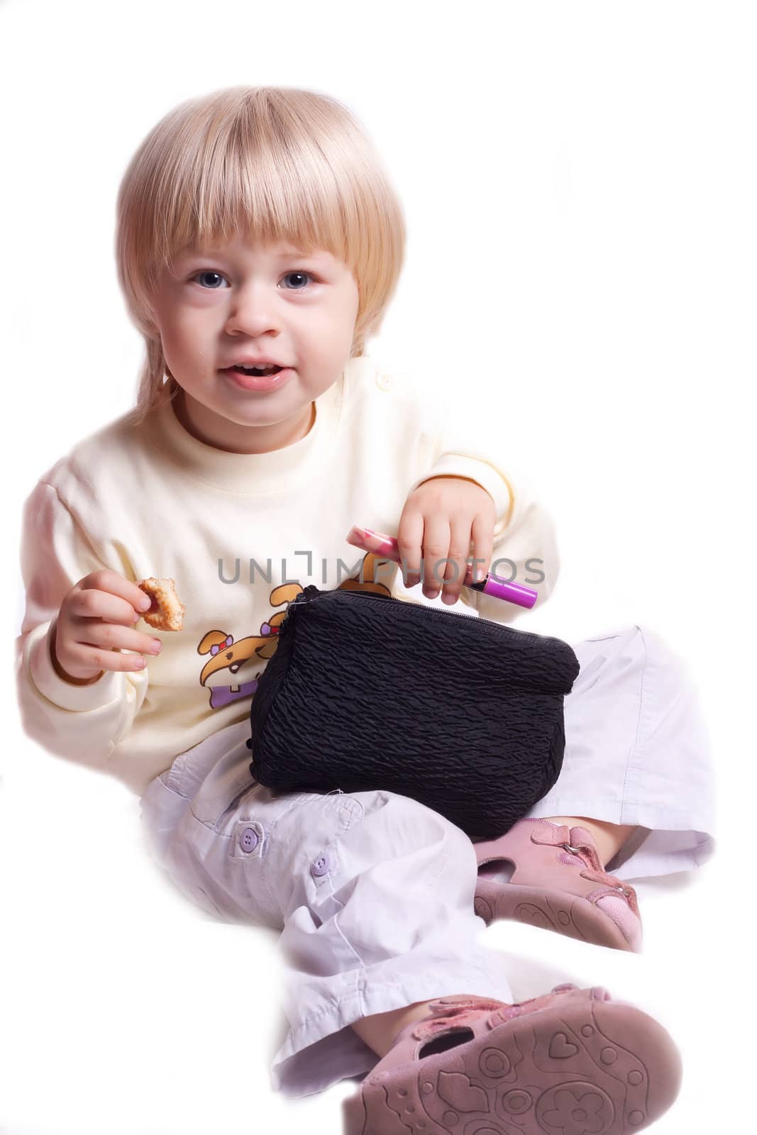 Little girl with cosmetics in the hands of a white background