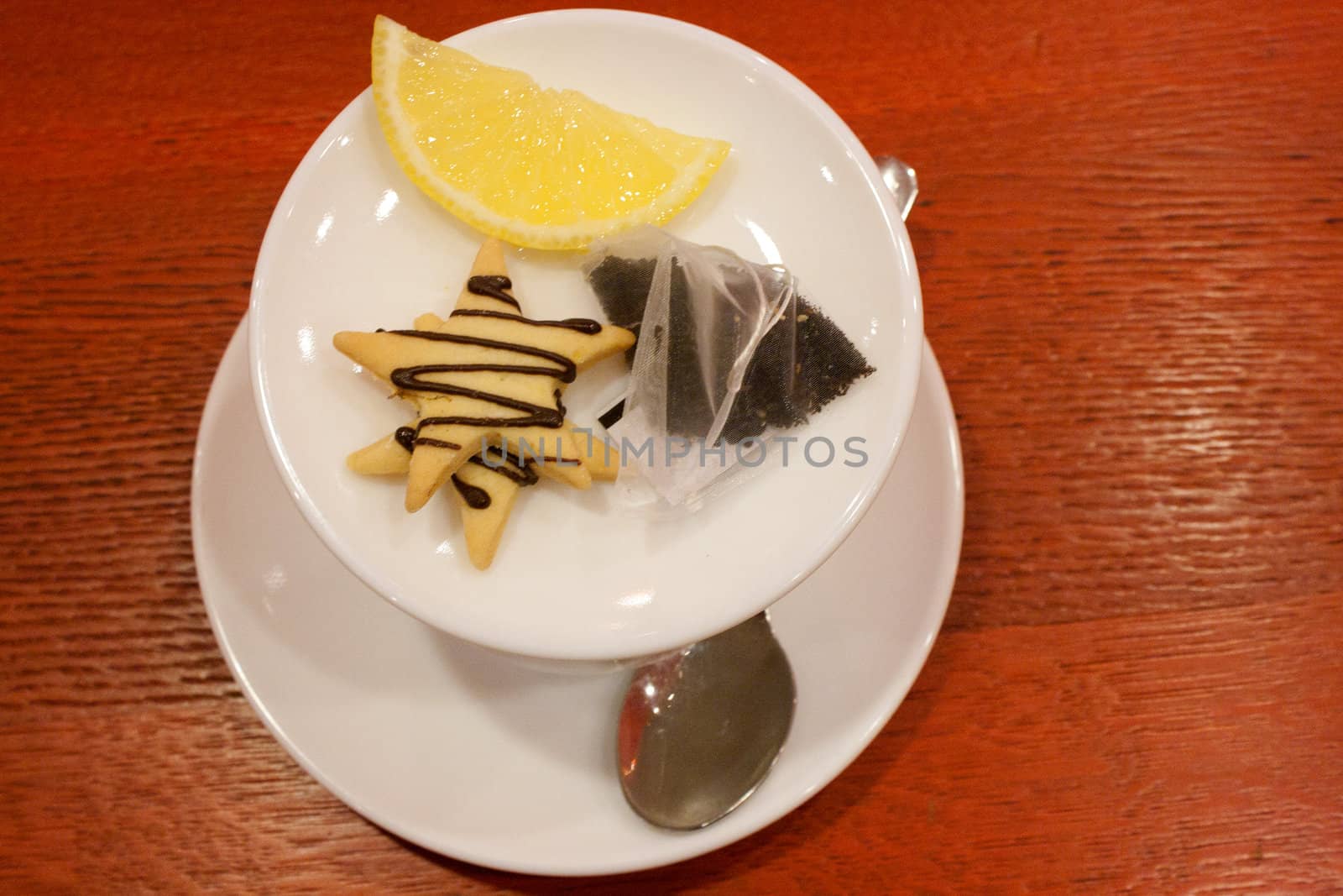 Tea bags, lemons, cookies, cup and spoon in a cafe shooting