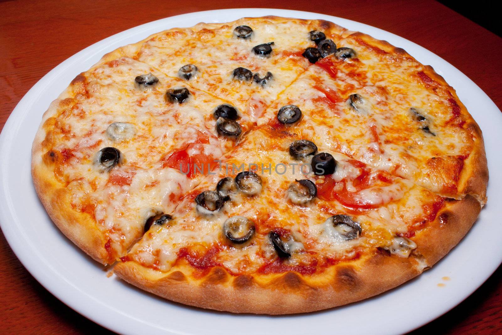 Pizza with black olives and melted cheese, close-up by victosha