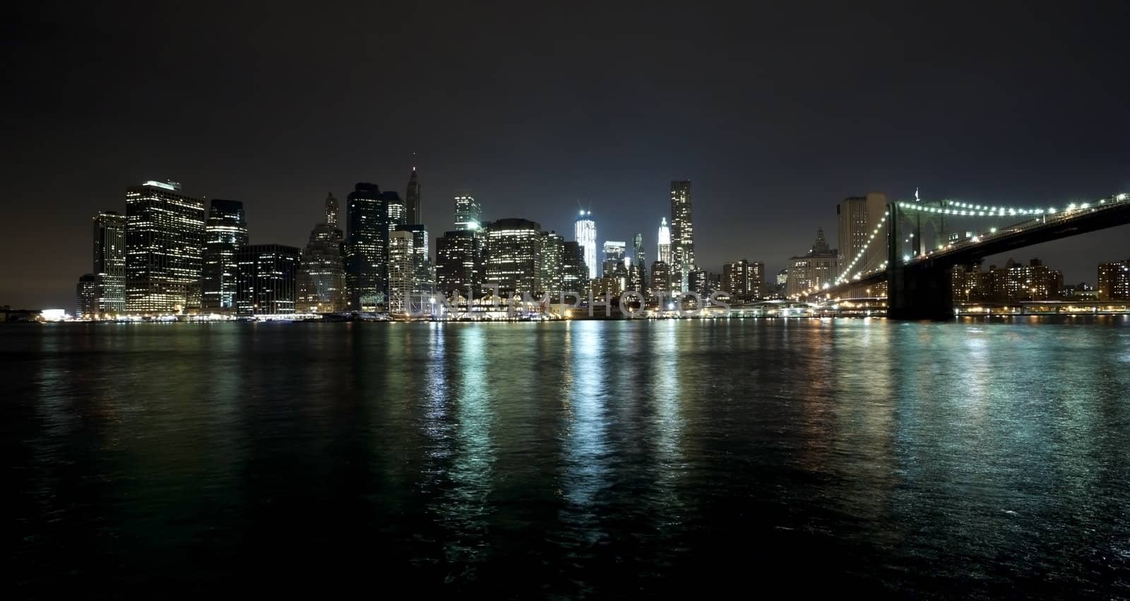 The New York City skyline at night w Brooklyn Bridge and Freedom tower