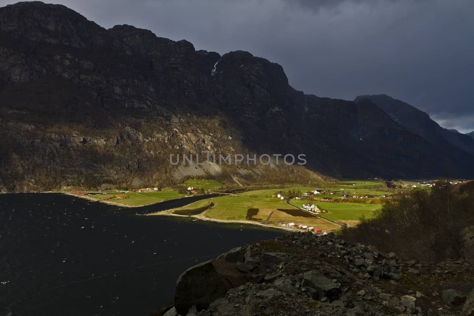 small, deep fjord in norway in changeful weather with cloudy sky