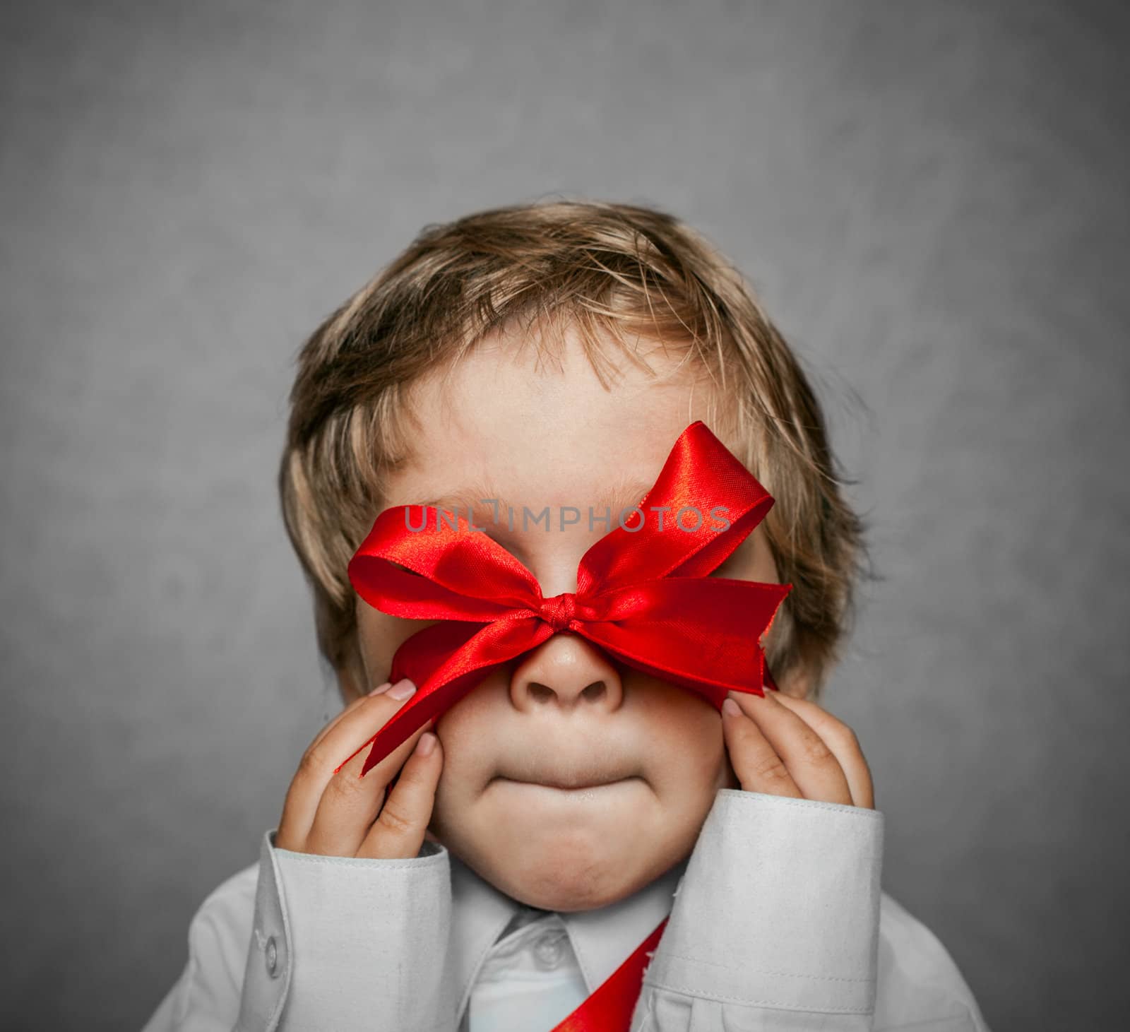 little boy with a red bow in hand