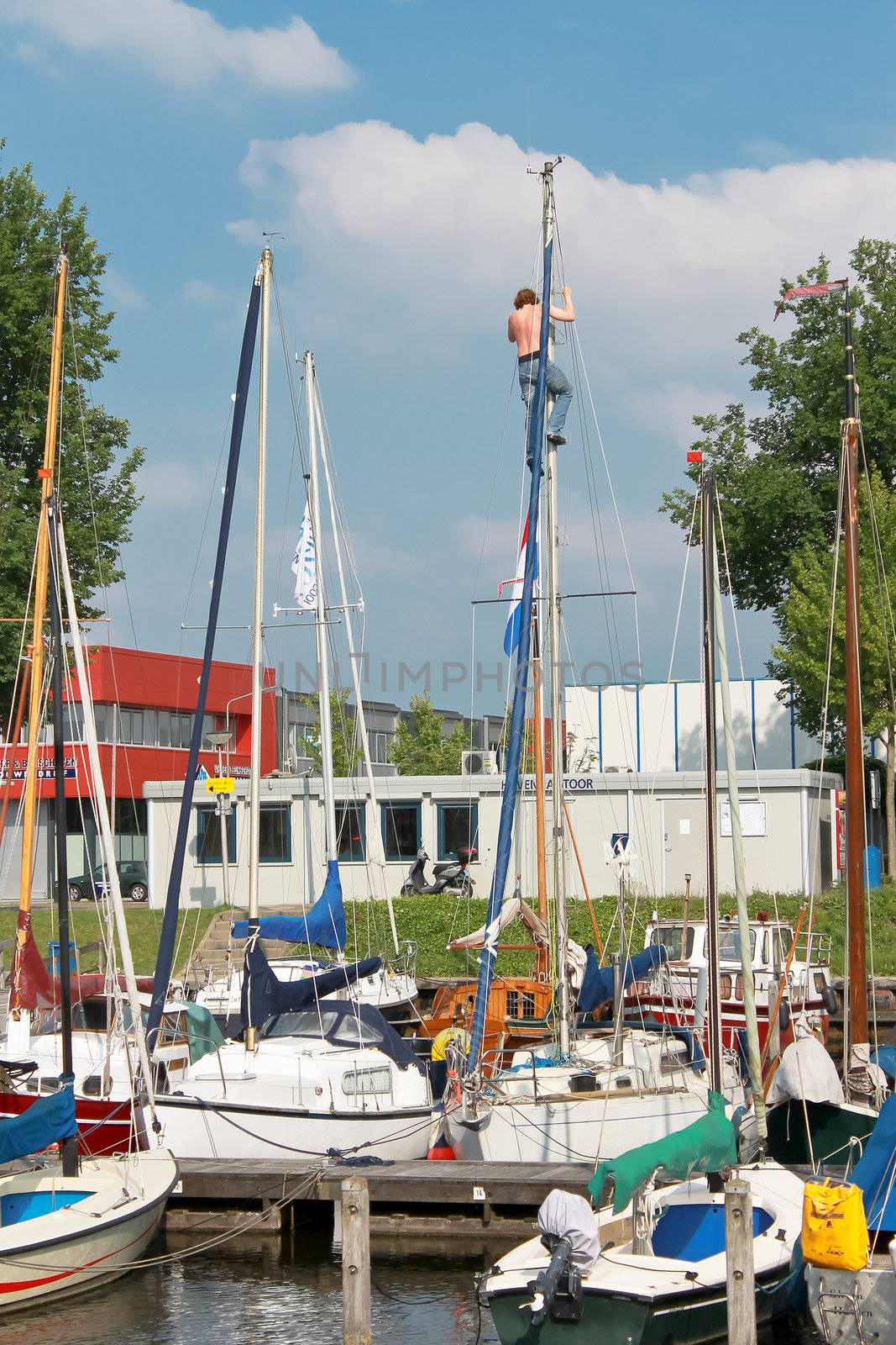 The man at the mast sailing yacht in the port of Huizen. Netherl by NickNick