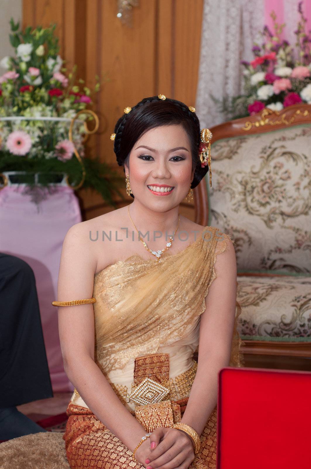 asian thai bride in thai wedding suit smiling in wedding ceremon by ngarare