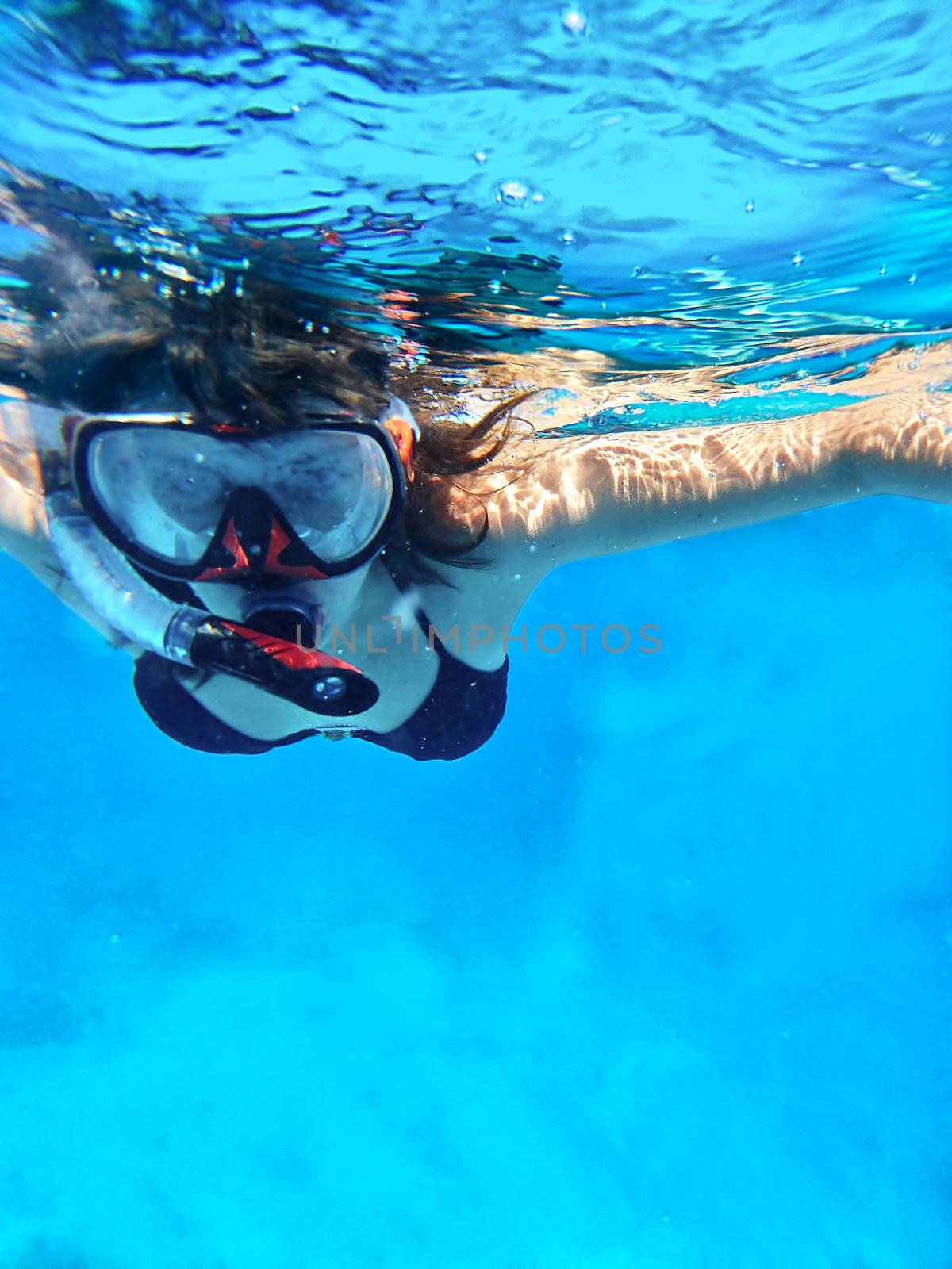 Woman swimming under water in snorkeling mask for looking marine life