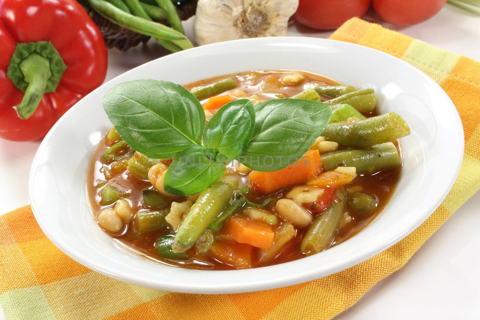 a bowl of minestrone soup and basil