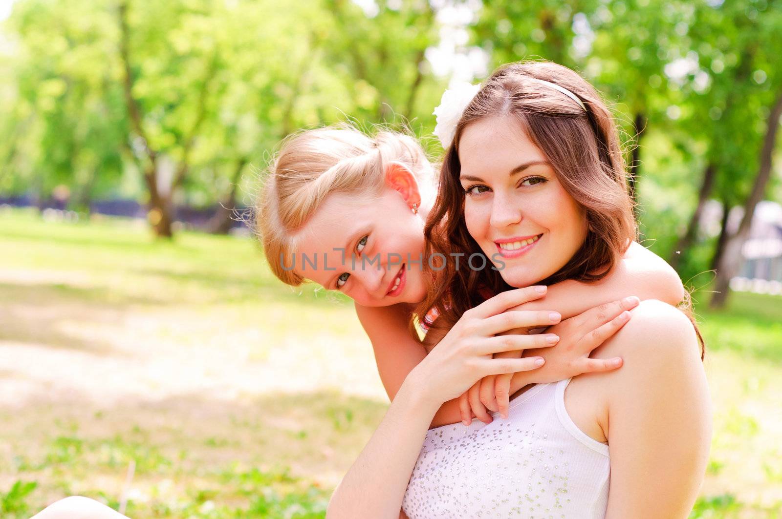 mother and daughter sitting together on the grass, and spend time with family