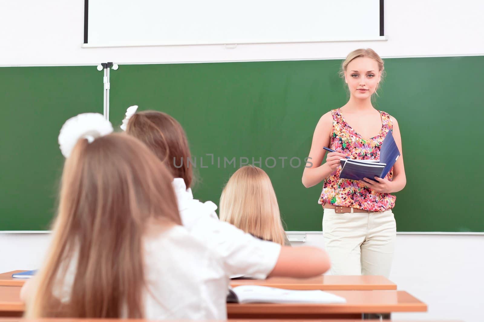 teacher stands in front of students in the class