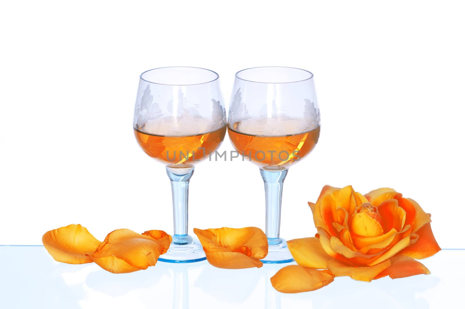 two tumblers with white wine and yellow rose on the party