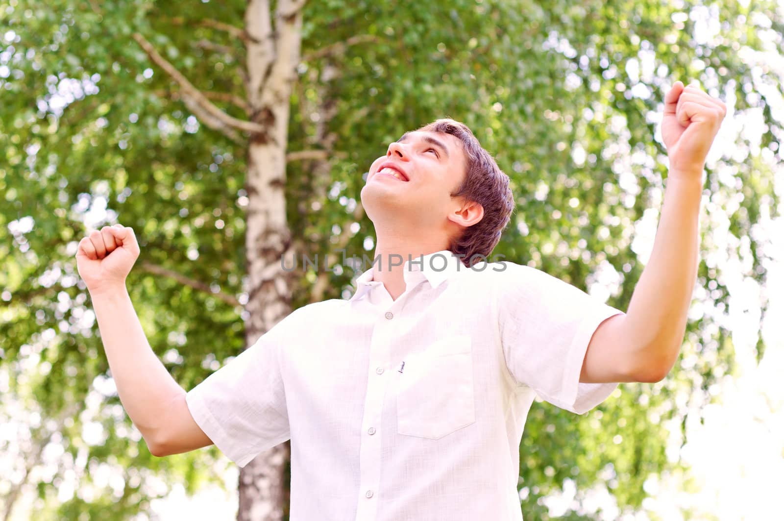 young man looking to the sky, holding his hands up, the expectation of success