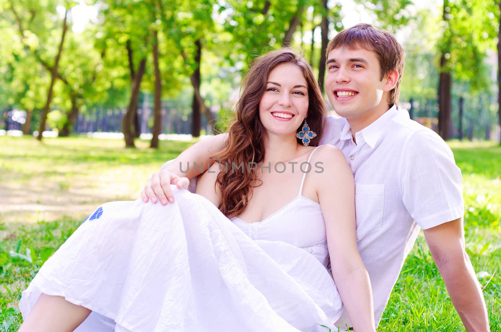 couple in the park sitting on the grass, have a good time together