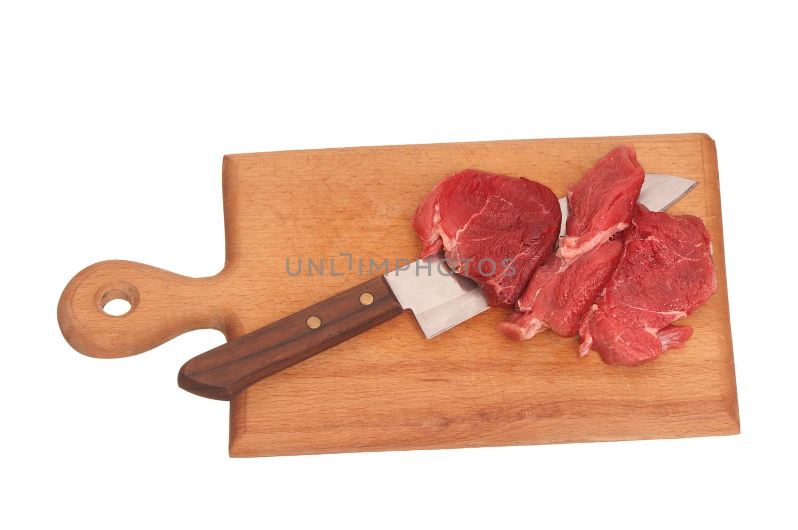 Slices of the meat on the board with knife on the kitchen