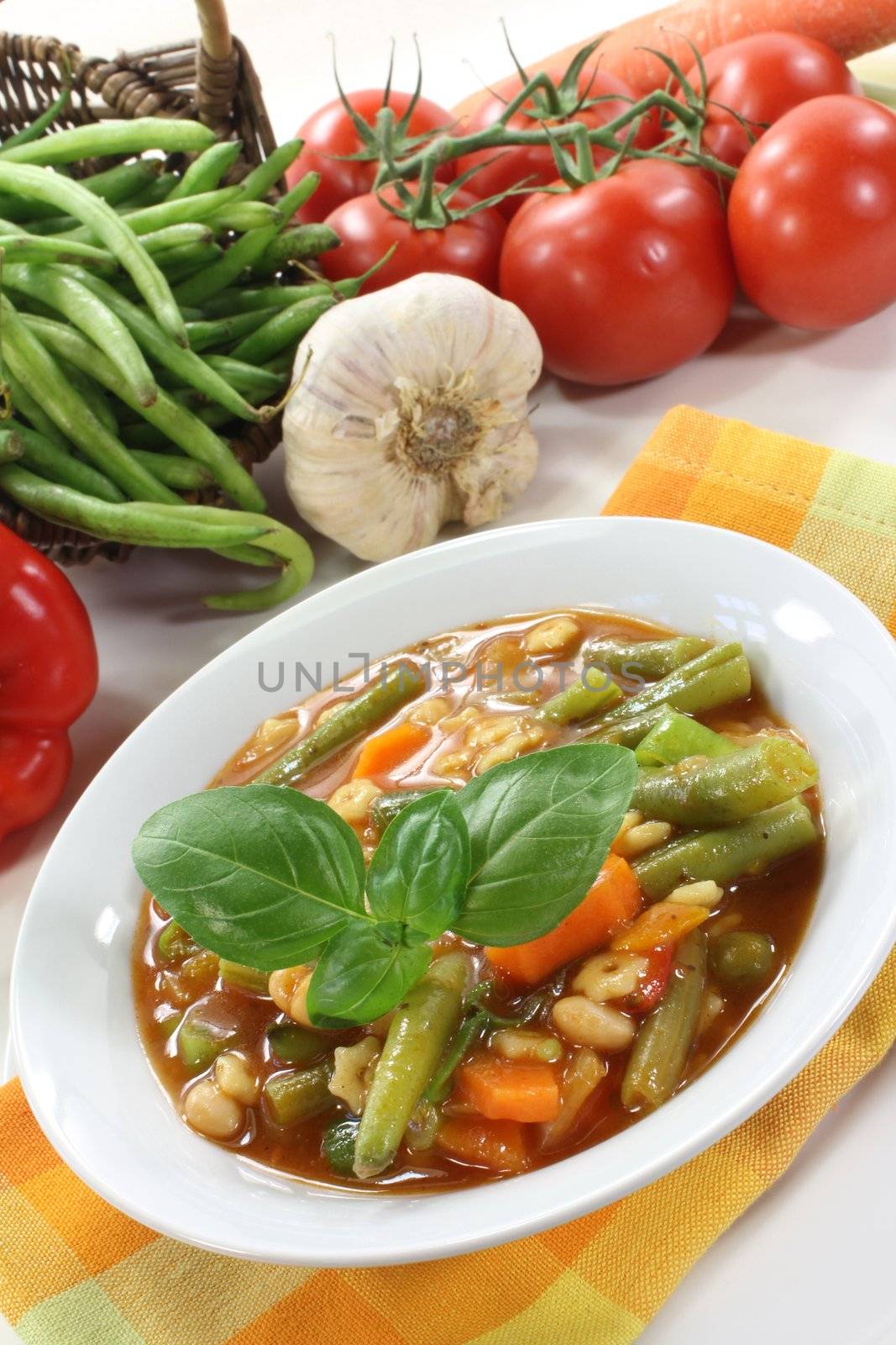 a bowl of minestrone soup and basil