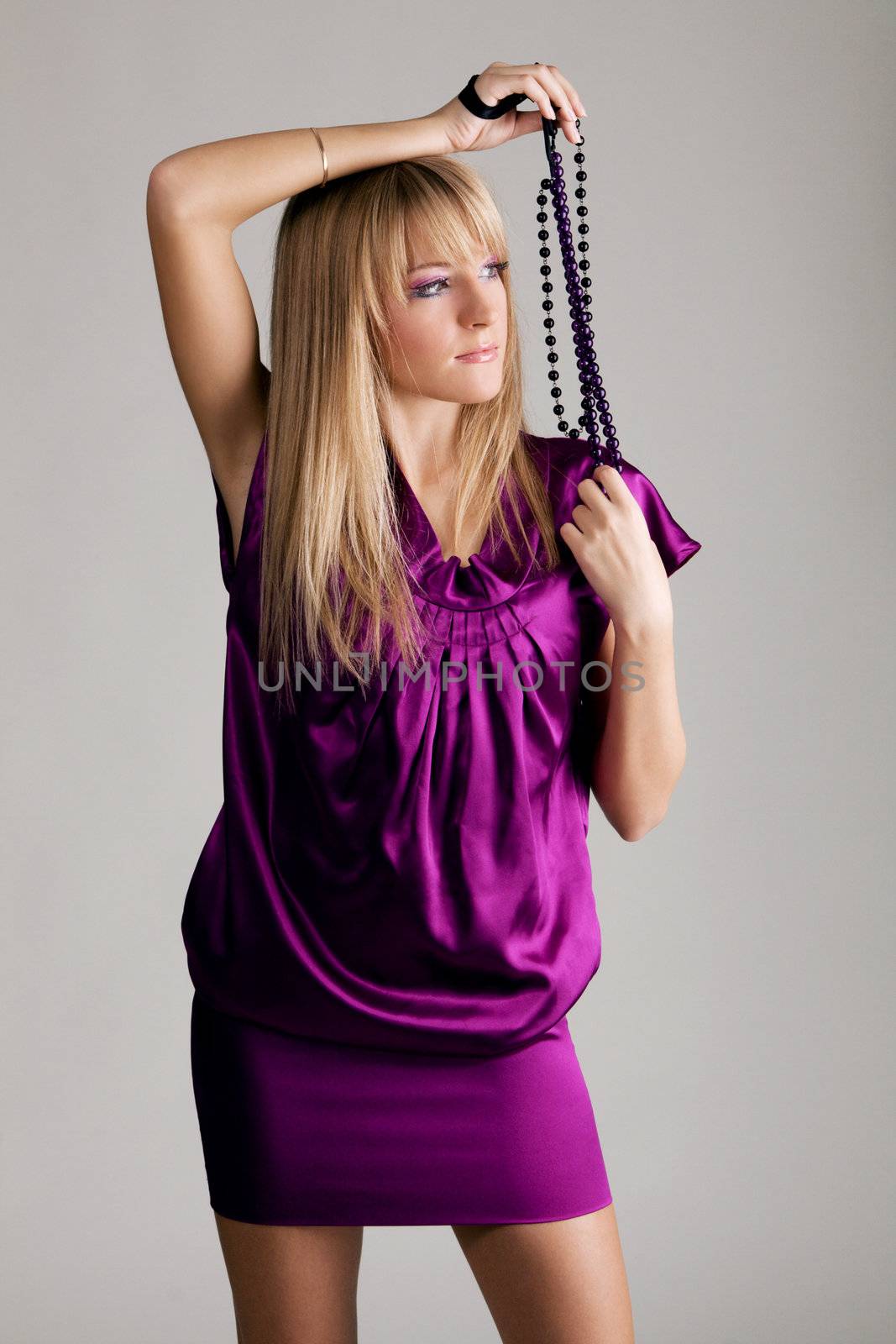 Beautiful lady in violet dress holding beads