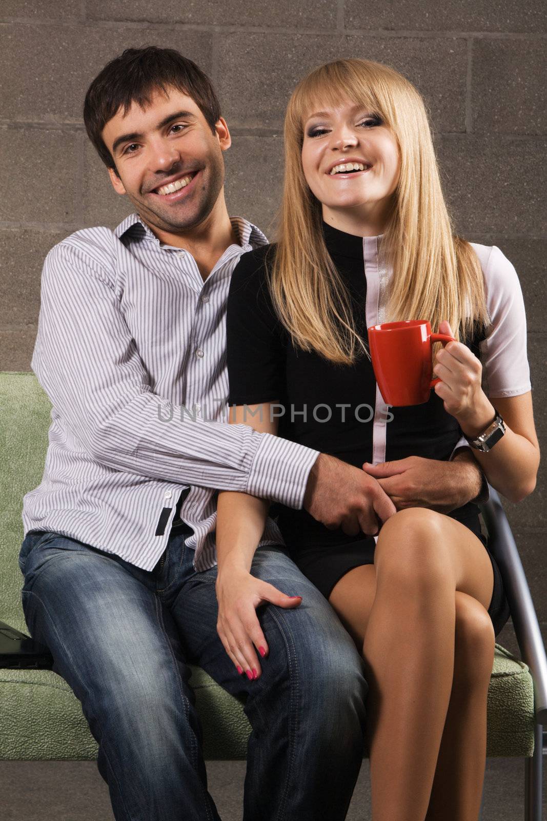 Young cheerful couple on brick wall background